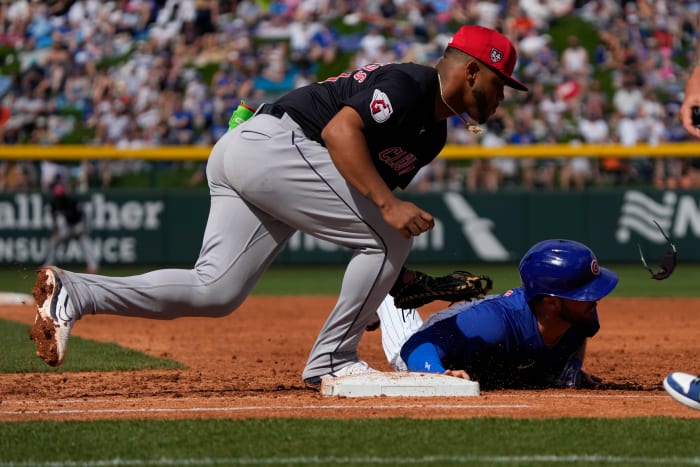 Mar 3, 2024; Mesa, Arizona, USA; Cleveland Guardians first baseman Deyvison De Los Santos (70) tags Chicago Cubs Joe Hudson (57) in the third inning at Sloan Park.